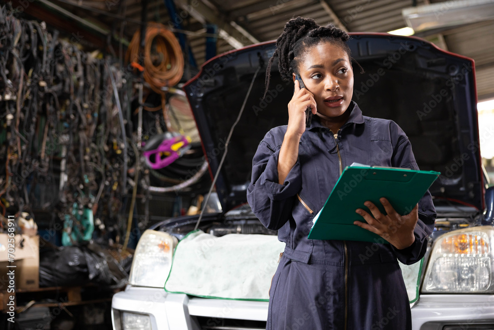 female worker or mechanic talking on smartphone with customer in garage
