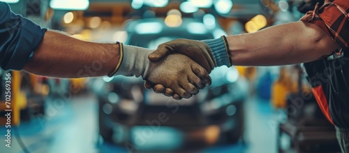 Mechanics shaking hands while repairing cars. photo