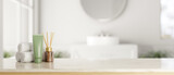 A white marble countertop with bath accessories with a blurred background of a modern white bathroom