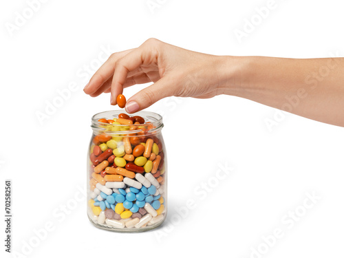 a hand taking a pill from a jar full of pills