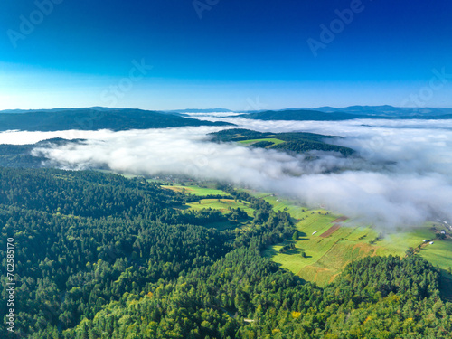 Lot nad Jastrzębikiem w mglisty poranek latem. Widok znad chmur.