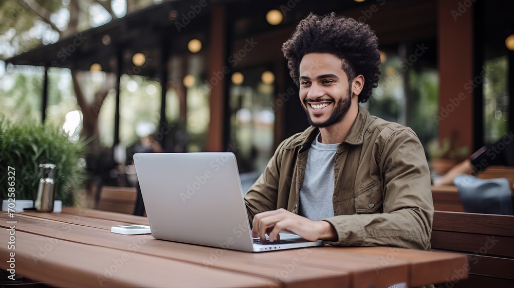 Happy young man smiling and working on laptop at outdoor Happy young man smiling and working on laptop at outdoor