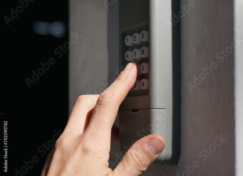 Fotografie Person using garage door keypad or keyless door access number pad