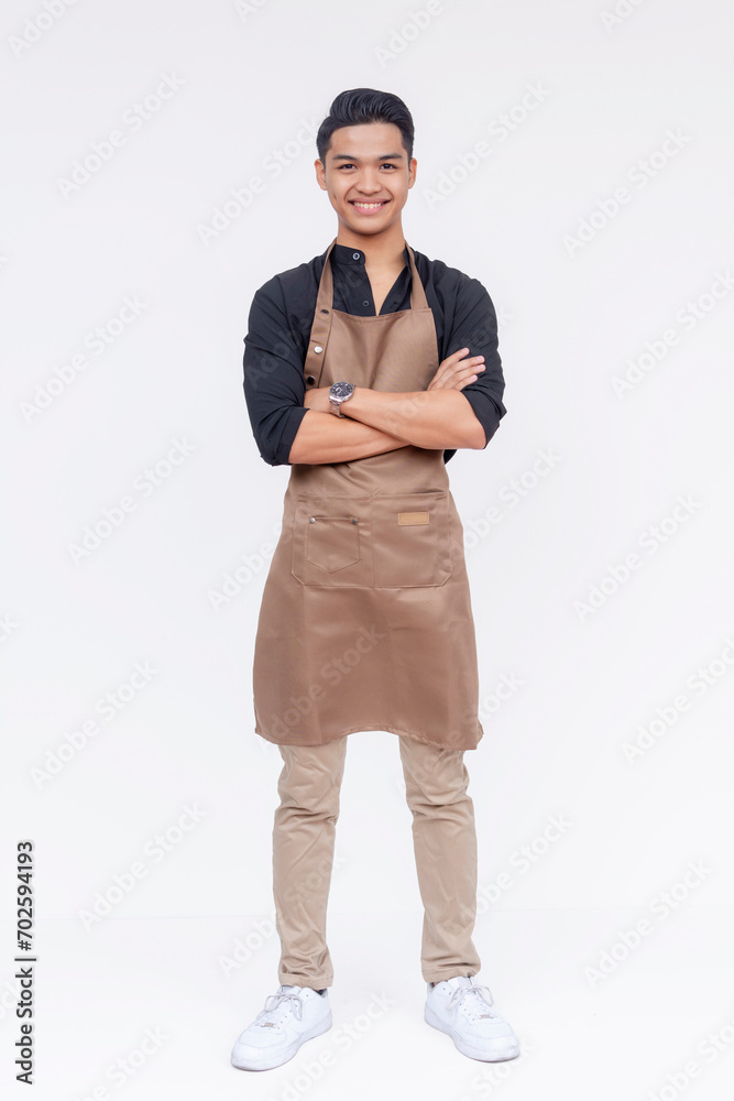 A handsome and young asian barista, arms crossed and standing. Full body studio shot, with white background. A handsome and young asian barista, arms crossed and standing. Full body studio shot, with white background.