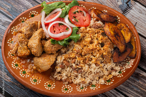 Rice congri with pork fricassee, salad and fried ripe plantain. Typical Cuban food. photo