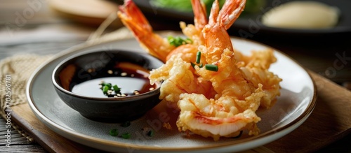 Single serving of tempura shrimp on a plate, with sweet and sour and soy sauces, appetizer concept.