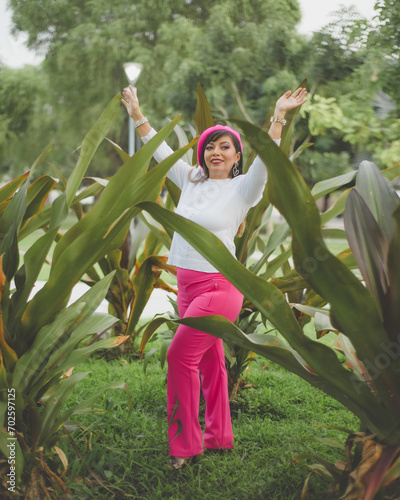Mexican woman among plants wearing pink beret. Mexican woman with positive attitude.