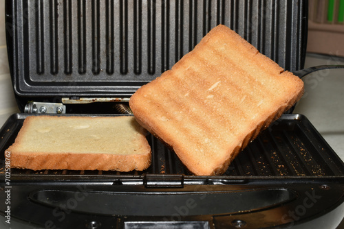 Toasted bread lies in the electric grill.