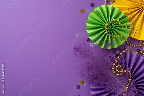 Carnival Splendor Snapshot  top view of exquisite traditional beads  feather  confetti  vibrant paper fans arranged on luxurious purple background  providing alluring space for your text or promotion