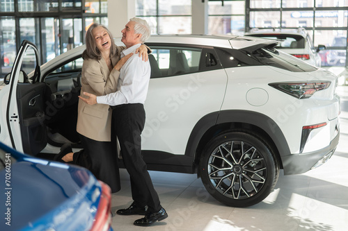 Mature Caucasian couple hugging with happiness while buying a new car.  © Михаил Решетников