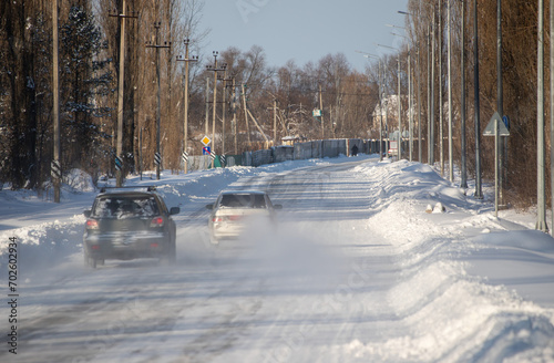 Overtaking a car on a snowy road, cold winter landscape.