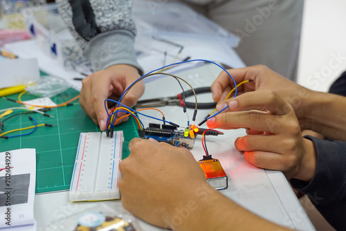 Students experiment with simple electronic circuits. Principles of traffic light circuits. Soft and selective focus.