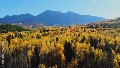 Dramatic bright sunny sunrise morning autumn Aspen Tree fall golden yellow colors Kebler Pass aerial cinematic drone  landscape Crested Butte Gunnison Colorado Rocky Mountains road trail forward up photo