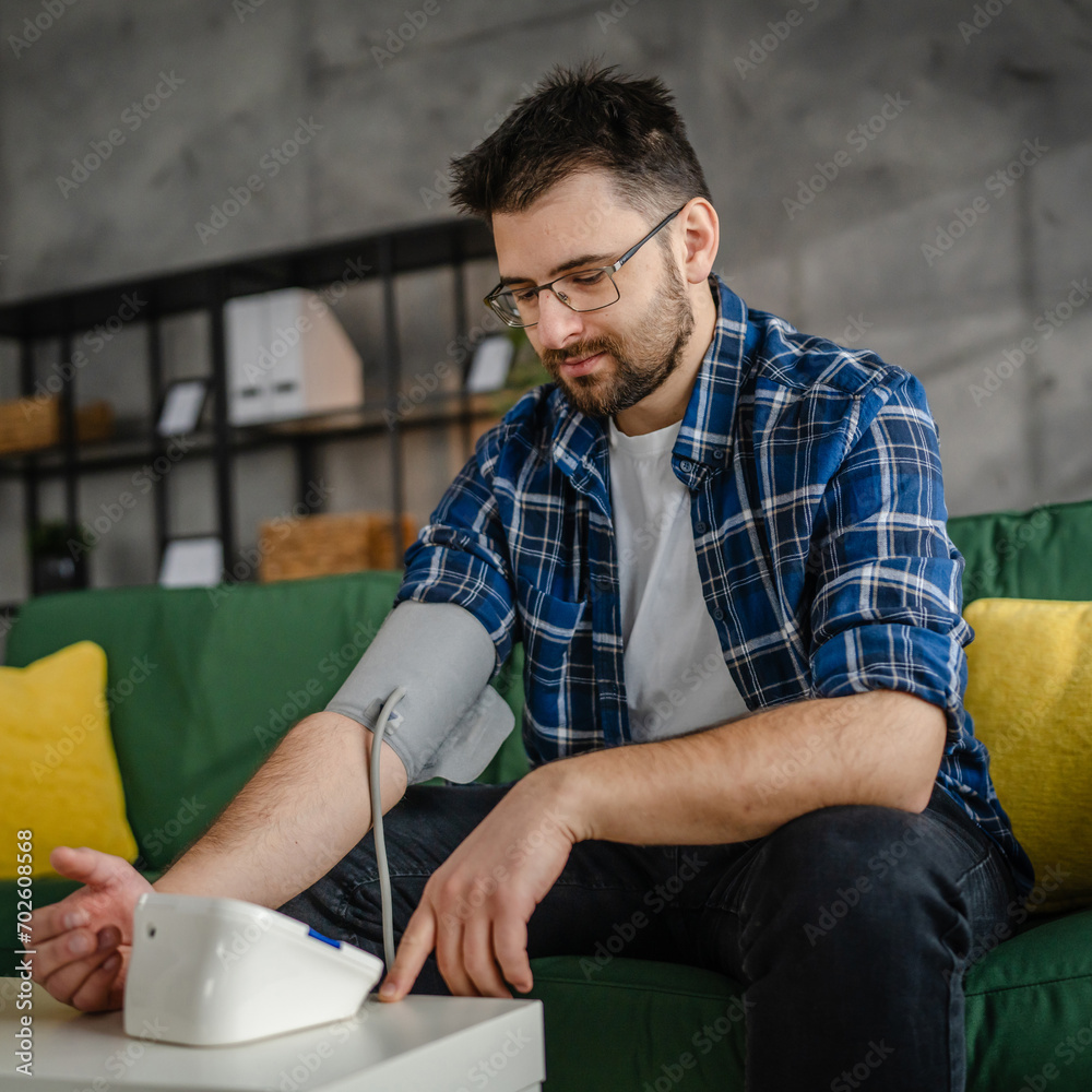 one adult caucasian man measure check blood pressure at home one adult caucasian man measure check blood pressure at home