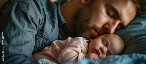 Exhausted father with sleeping baby experiences postpartum depression at home. photo