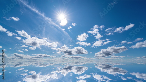 futuristic background consisting of Time lapse clip of white fluffy clouds over blue sky and their reflection, video loop. 4k
