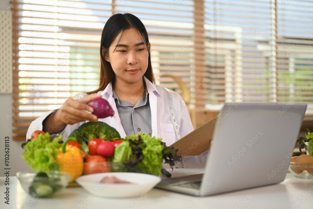 Asian female nutritionist having online consultation with her patient via laptop computer. Asian female nutritionist having online consultation with her patient via laptop computer.