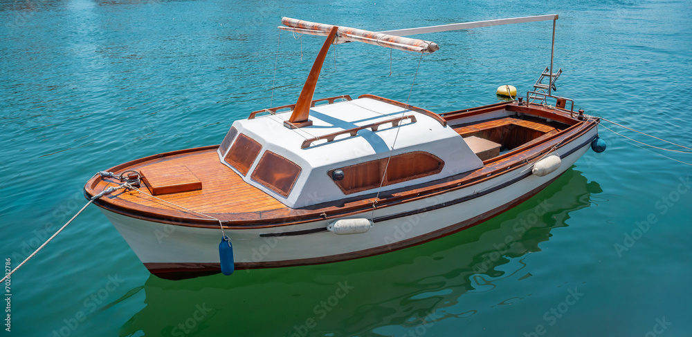 Fishing and pleasure boats on the pier on the blue sea.