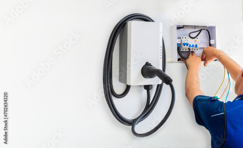 Obraz na plátně Certified male Electrician Installing Home EV Charger