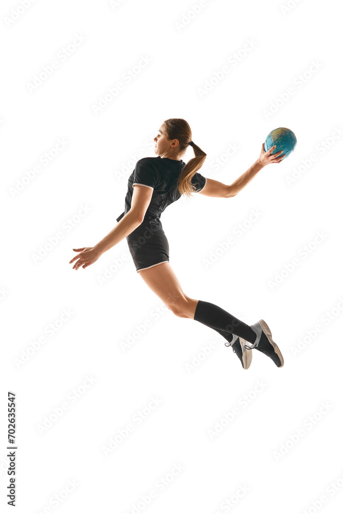 Determined woman, handball player in action, exhibiting focus and energy during training against white background. Concept of professional sport, hobby, movement, dynamic, workout, championship. Ad