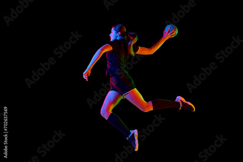 Talented handball player  female sportsman practicing techniques  capturing intensity of sport against black background in neon light. Concept of hobby  movement  dynamic  lifestyle  championship. Ad