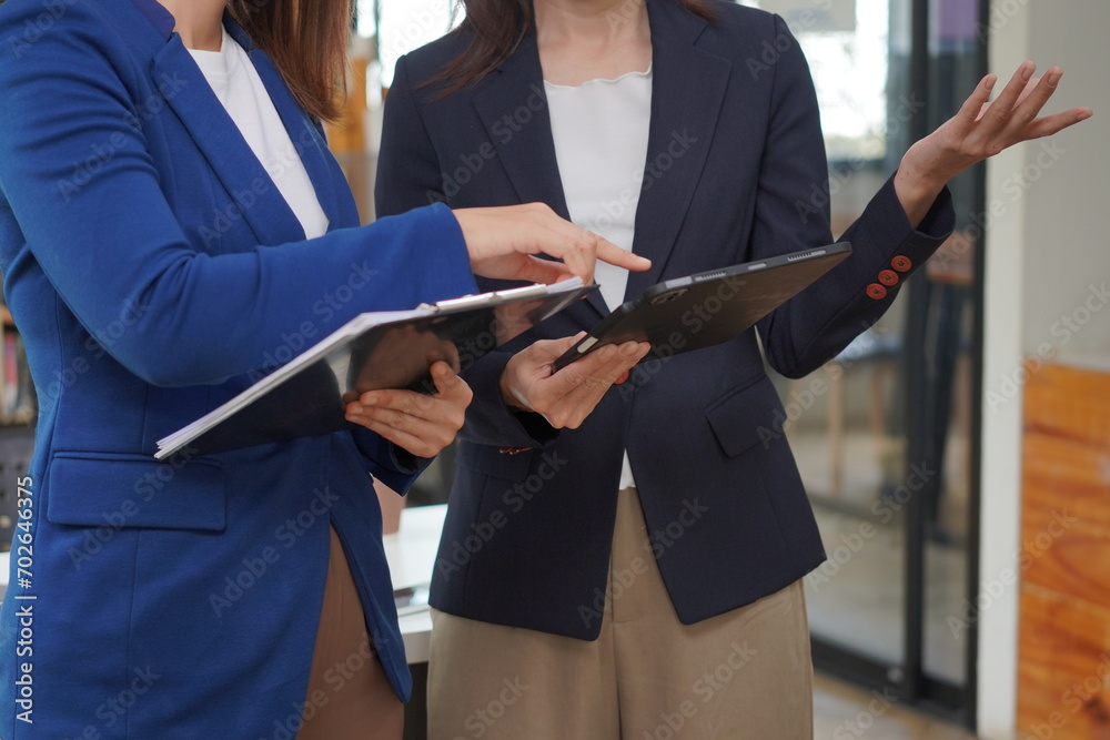 Two beautiful Asian employees enjoying successful work and confidently holding hands to work productively together at the office. Businessman, employee, African, laptop.