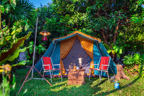 vintage cabin tent,  Antique oil lamp, retro chairs, Group of camping tents with outdoor coffee-making facilities on wooden tables in a forest camping area in the forest.