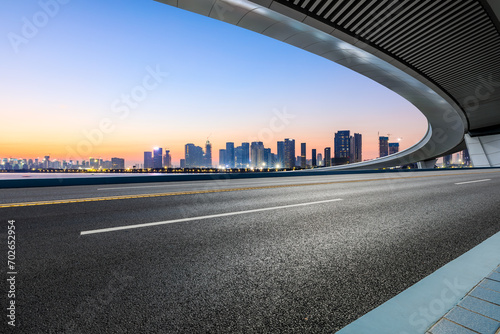 Asphalt road and bridge with modern buildings scenery at sunrise