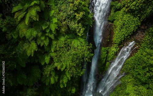 Valokuva Majestic waterfall cascading down from a great height, surrounded by lush green