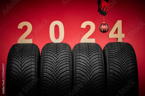 Winter car tires, hand of mechanic man with christmas ball, 2024 background