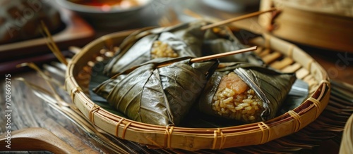 Zongzi, a Chinese festival food, is made by steaming a mixture of glutinous rice, salted egg, sausage, and dried shrimp wrapped in bamboo leaves.