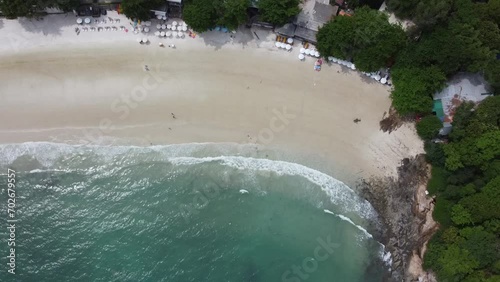 top view of white beach with people resting and umbrellas by the sea in summer
