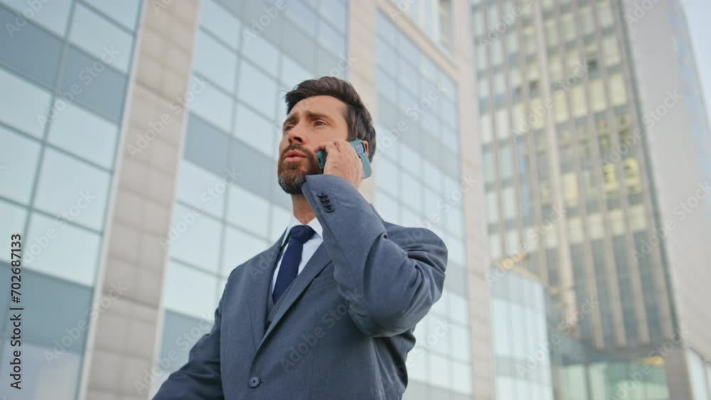 Company worker talking mobile phone walking urban business district close up. Company worker talking mobile phone walking urban business district close up.