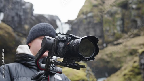 Male videographer hold electronic gimbal with camera in Icelandic landscape photo