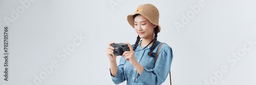 Young girl taking a picture with a small camera on a white background photo