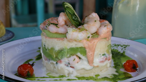 Causa rellena de langostinos, palta y papa, Causa stuffed with prawns, avocado and potato photo