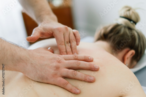 Young fat woman getting massage treatment in day spa cabinet.