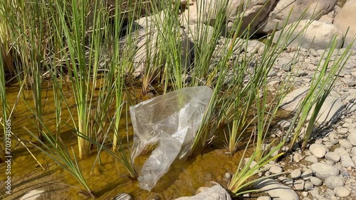 polluted Wadi Al Arbeieen river course and natural pond for a quick swim and bath, Oman, Muscat with plastic trash and packaging photo