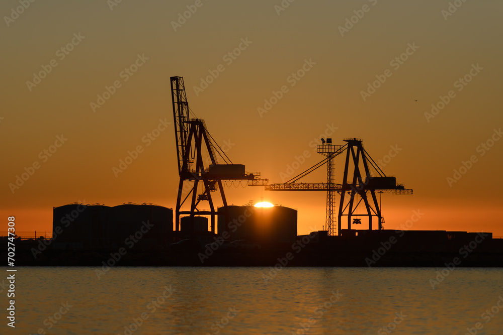 port cranes against sunset background
