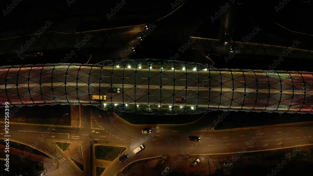 Aerial high angle night shot of an illuminated bridge. Top down drone footage of a modern LED concrete bridge. Traffic driving over an lit up urban bridge.
Aerial high angle night shot of an illuminated bridge. Top down drone footage of a modern LED concrete bridge. Traffic driving over an lit up urban bridge.