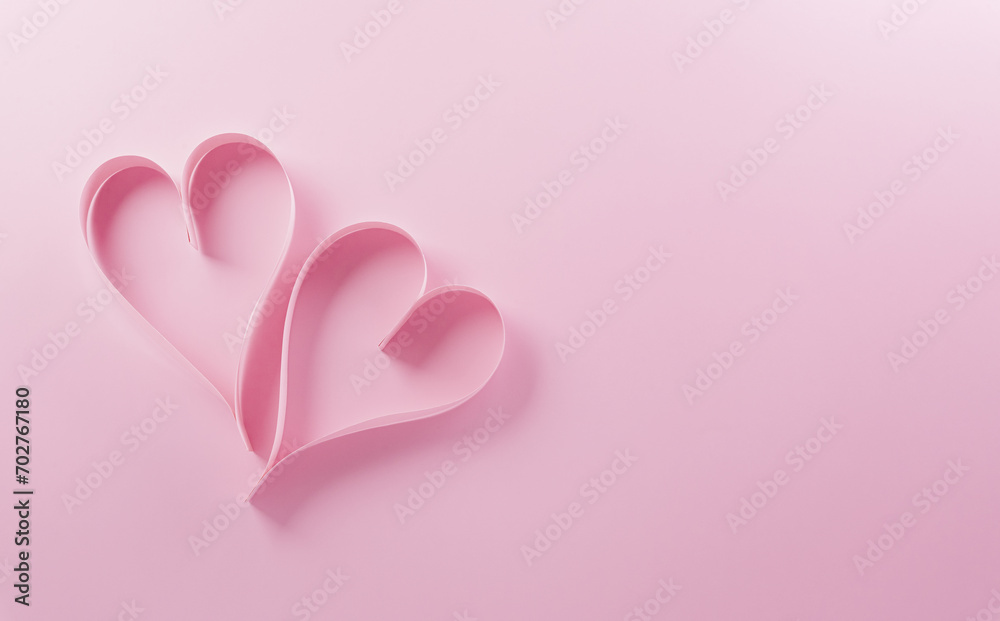 Love and Valentine's day concept made from pink paper hearts on pastel background.