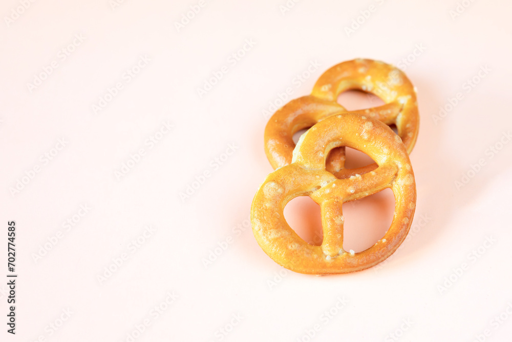 two little salty pretzels on a light peach background two little salty pretzels on a light peach background