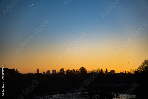 Park in Munich  Germany  skyline of trees and the City in the sunset