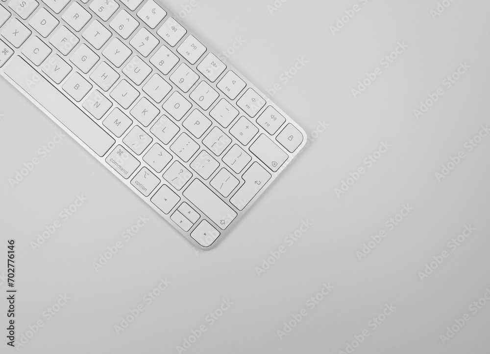 Top view of white keyboard on light grey background. Modern office flat lay, copy space. Top view of white keyboard on light grey background. Modern office flat lay, copy space.