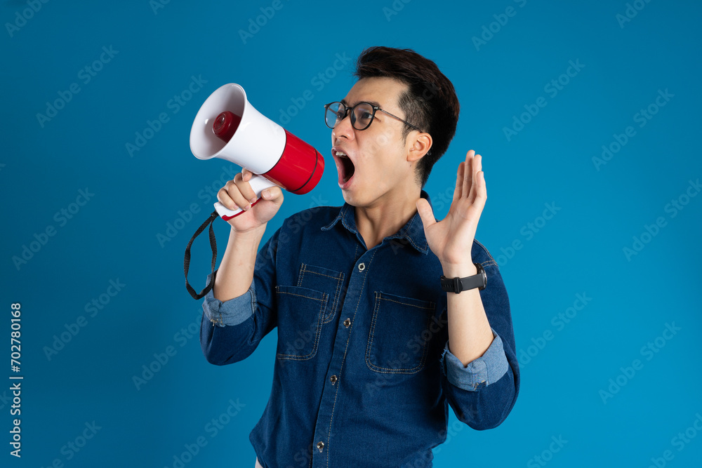 Portrait of young Asian business man posing on blue background Portrait of young Asian business man posing on blue background
