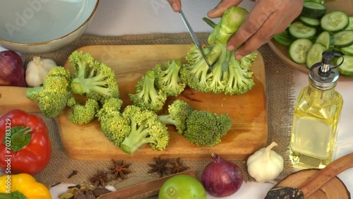 Detail shot of slicing up broccoli on wooden cutting board