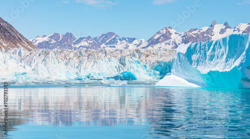 Knud Rasmussen Glacier near Kulusuk - Melting icebergs by the coast of Greenland, on a beautiful summer day - Melting of a iceberg and pouring water into the sea, East Greenland