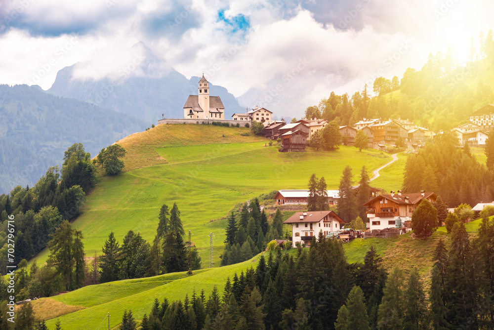 Panoramic view of mountain village with a church in Dolomite alps