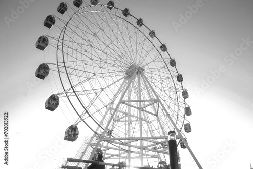 Big, tall white Ferris wheel in front of a perfect blue sky at the oceanfront in satellite town theme park jehlum punjab pakistan. Happy summer vacation feelings. photo
