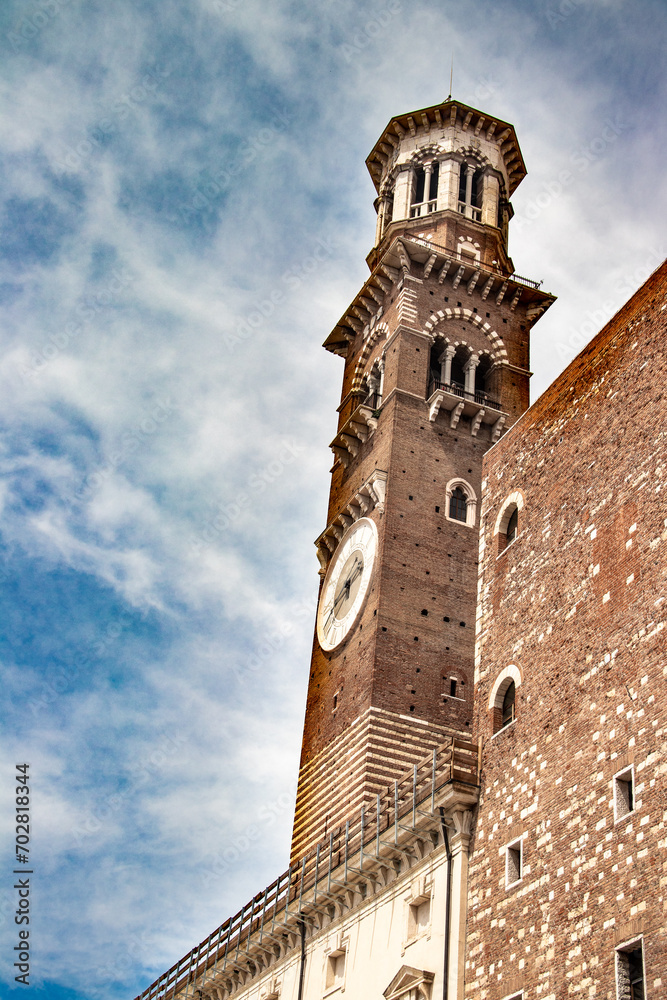 Medieval Lamberti (Torre dei Lamberti) tower XI century with clock, 84 metre and antica ancient column (1400 a.D) on Erbe Square in Verona city. Medieval Lamberti (Torre dei Lamberti) tower XI century with clock, 84 metre and antica ancient column (1400 a.D) on Erbe Square in Verona city.